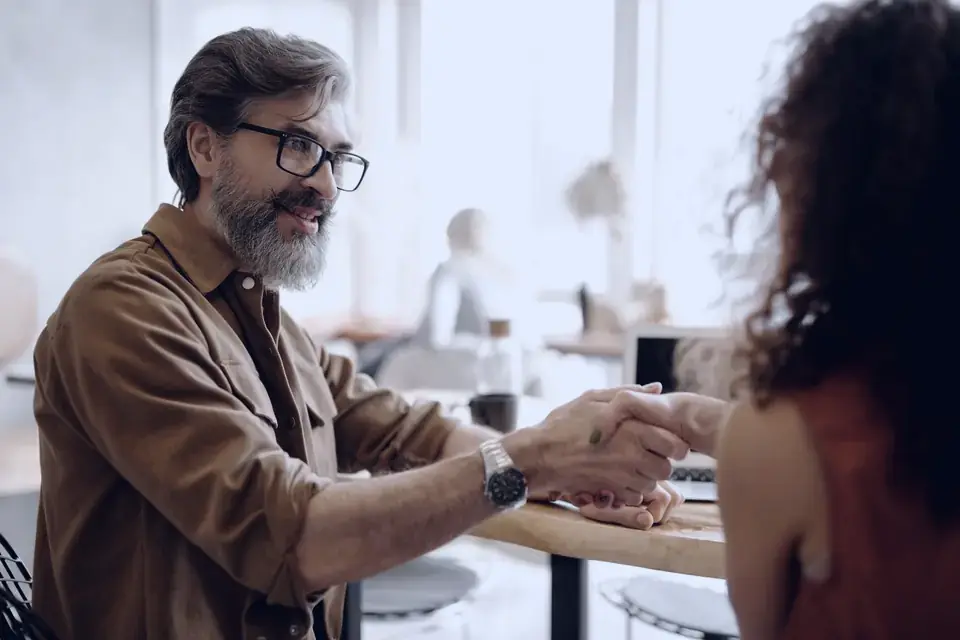 A handshake across a desk at the start of a website project